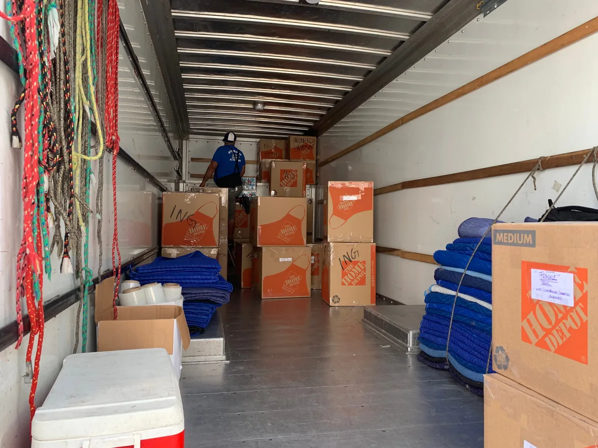 Cajas, mantas y equipo organizados dentro de un camión de mudanza